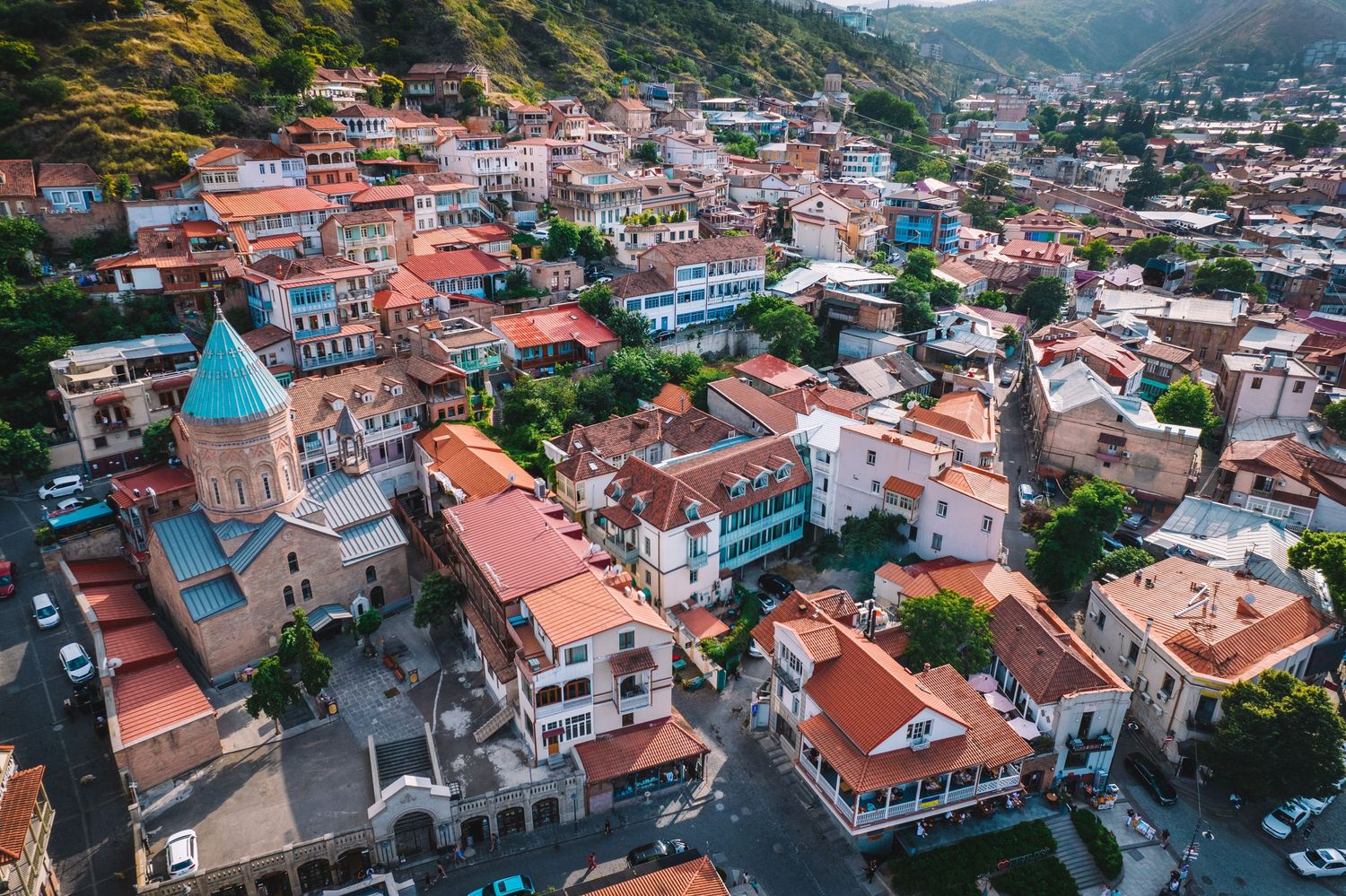 High-resolution drone photo of residential houses with red rooftops and narrow streets.