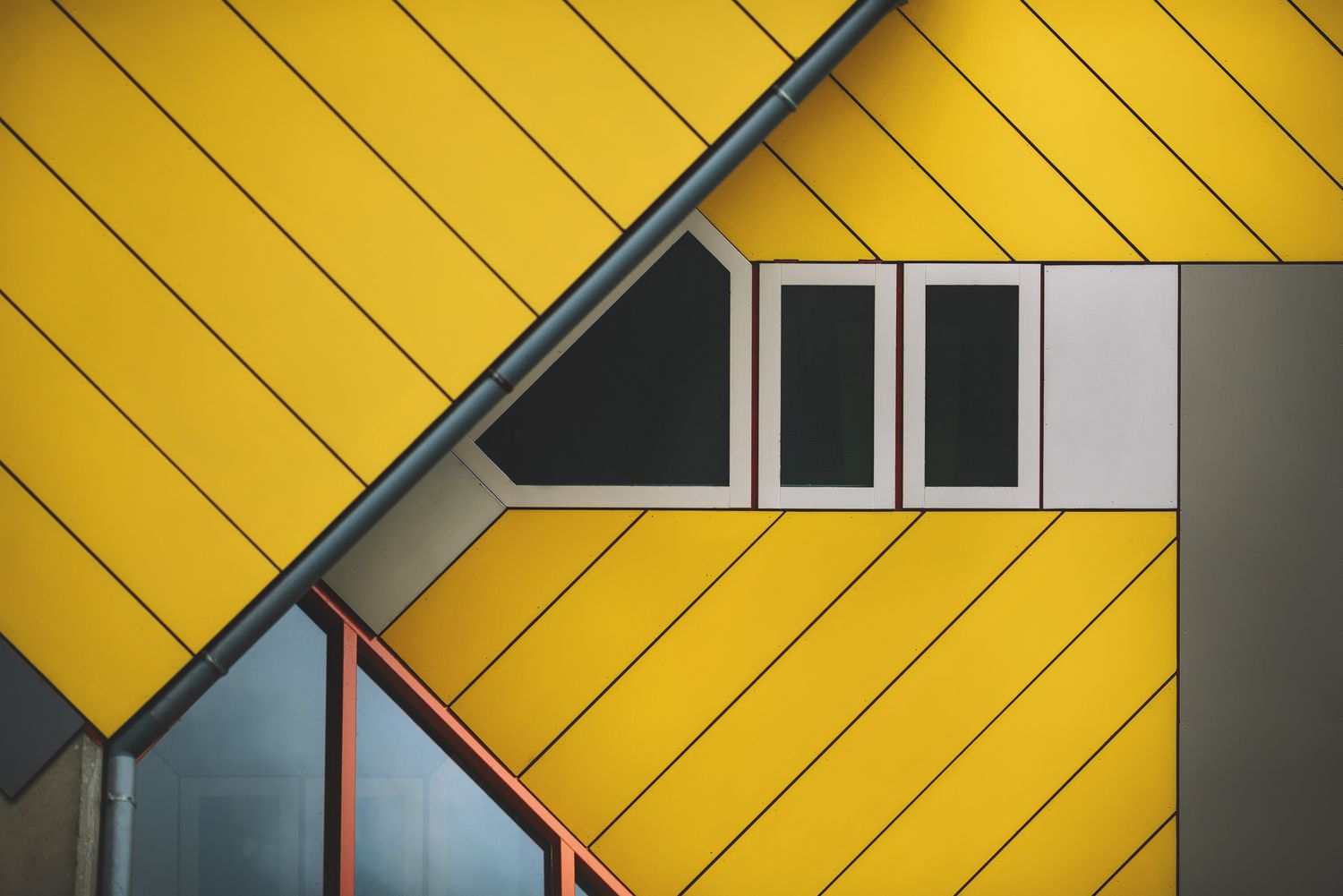 Close-up of modern architecture with yellow cladding and geometric window design — minimalistic building detail.