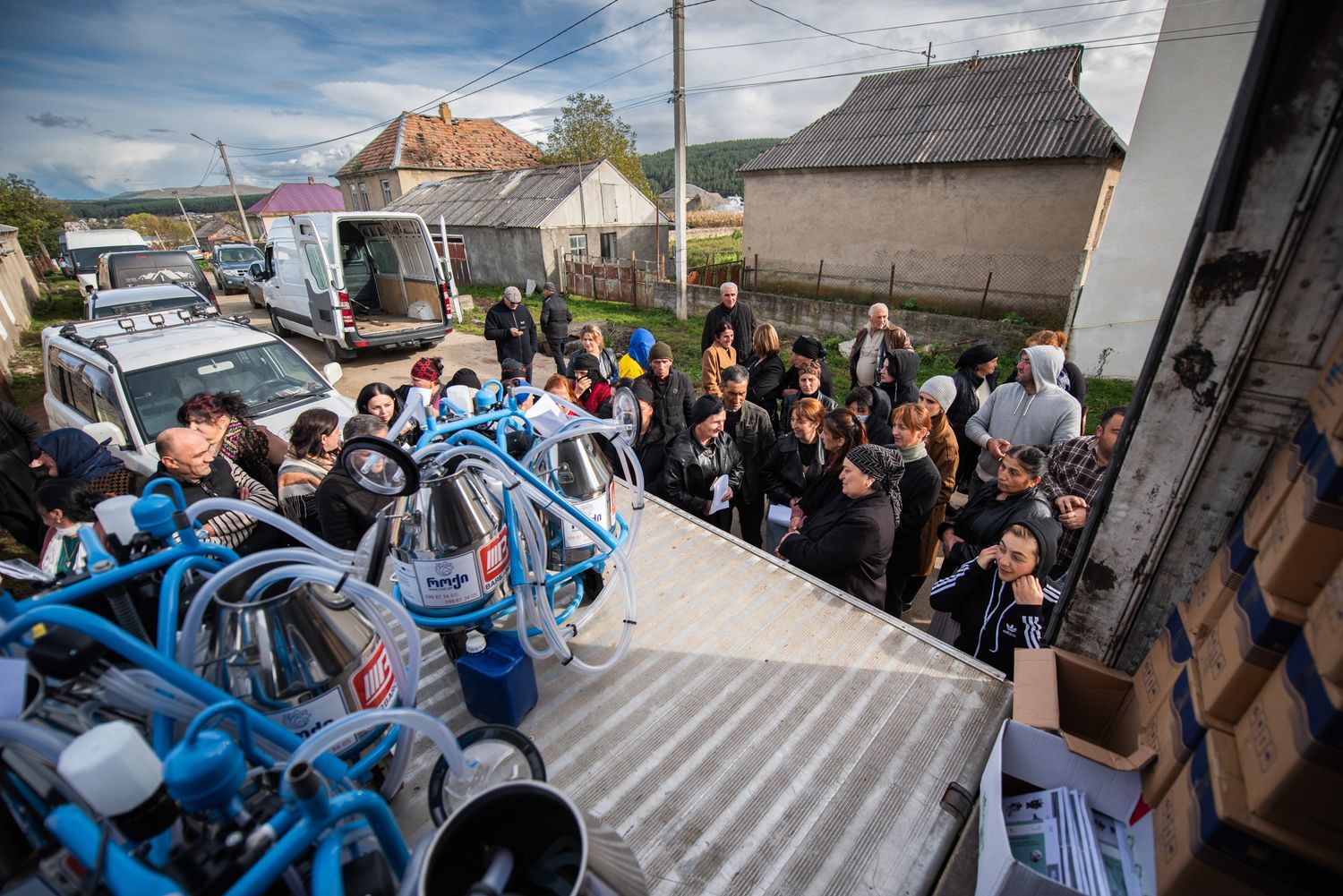 Community members unloading supplies from a van during a rural project.
