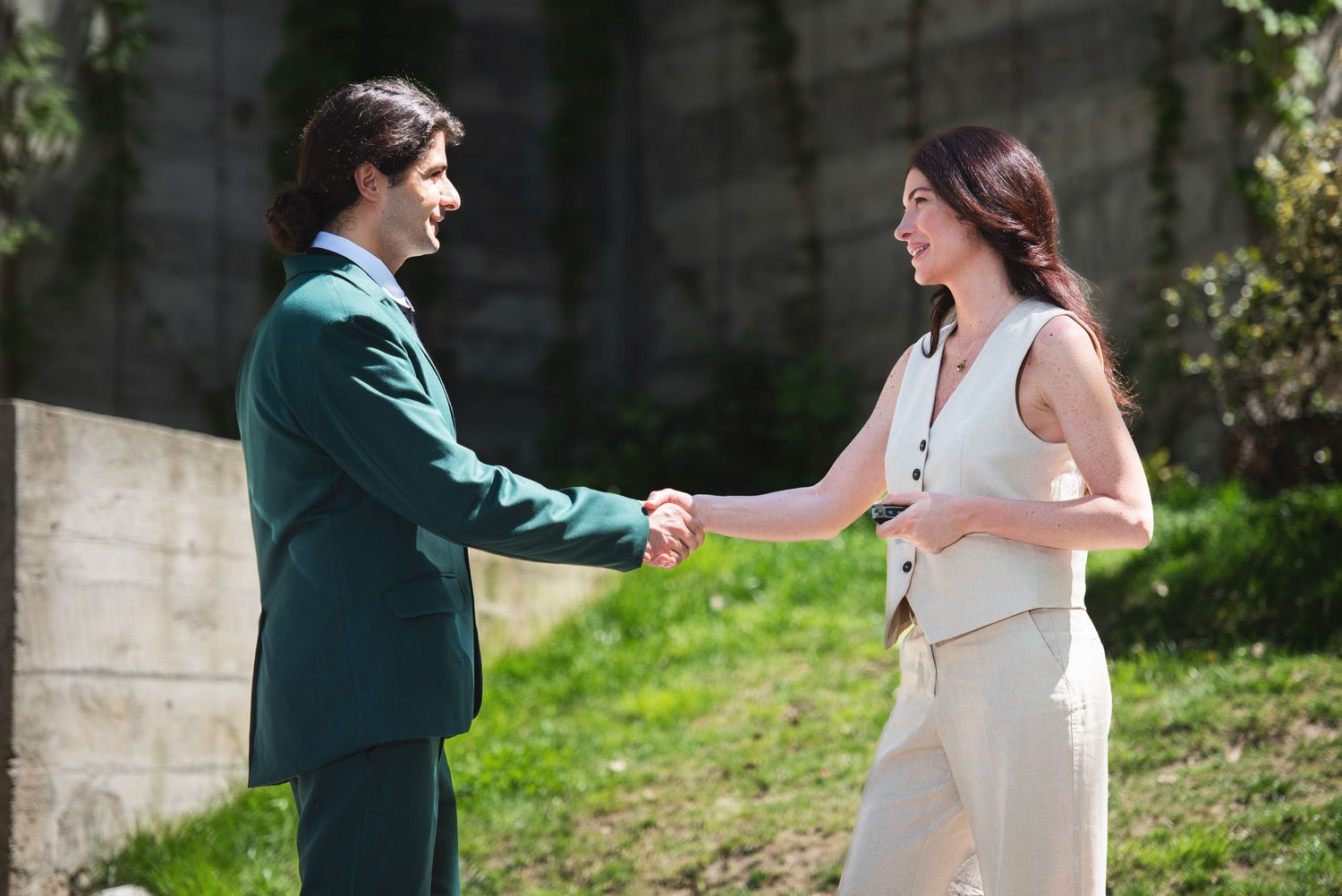 Man and woman facing each other in a light moment — informal outdoor interaction in daylight.