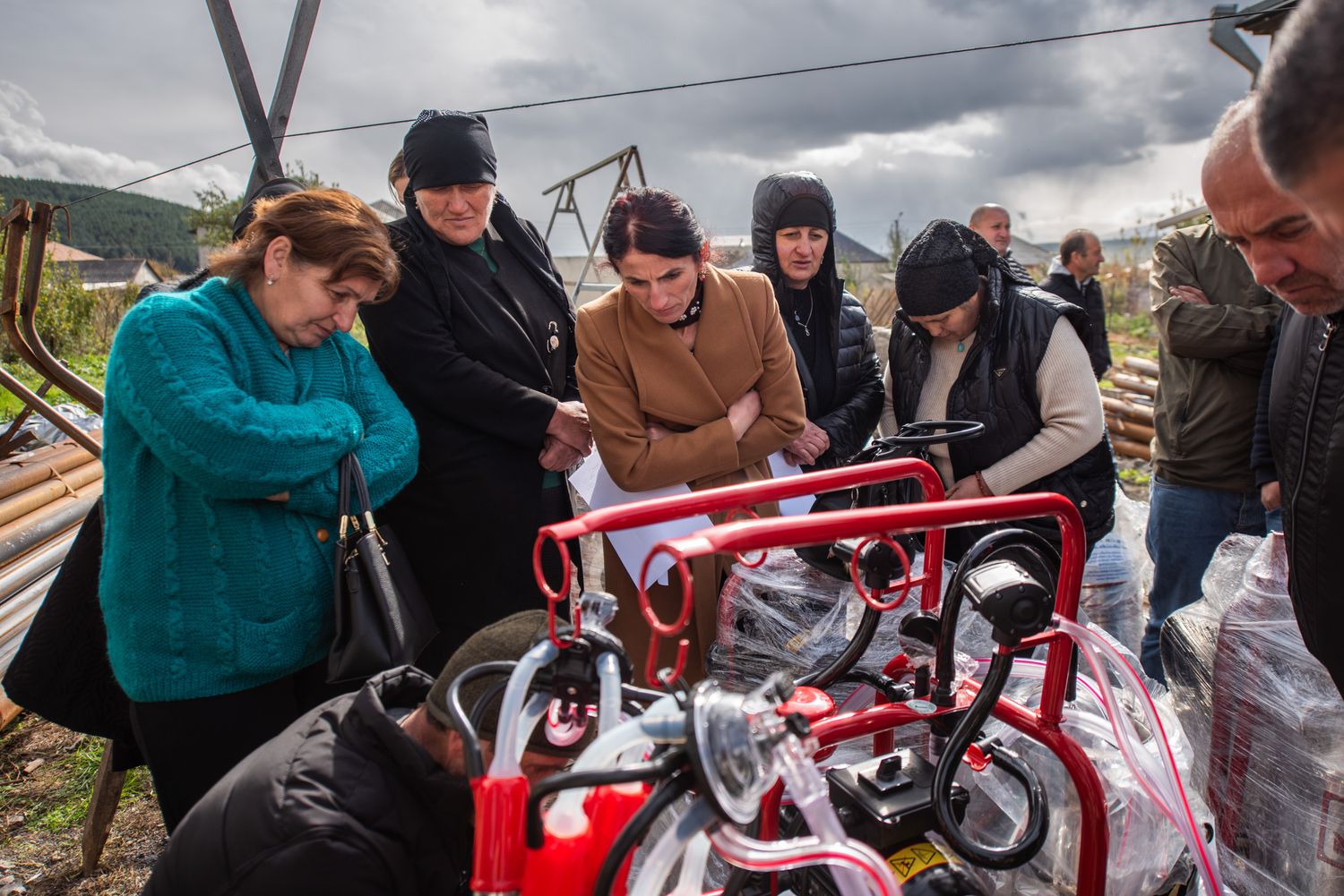 Workshop participants assembling a mechanical structure in an outdoor setting.