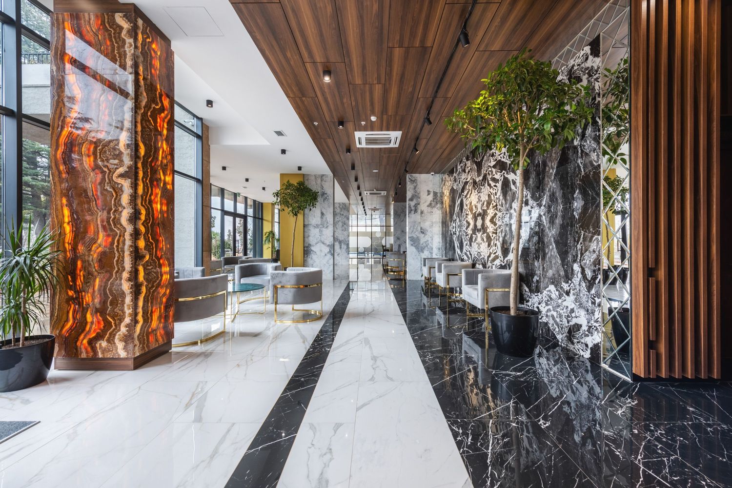 Luxurious hotel or office corridor with marble floors, wooden details, and indoor greenery, designed in a contemporary style.