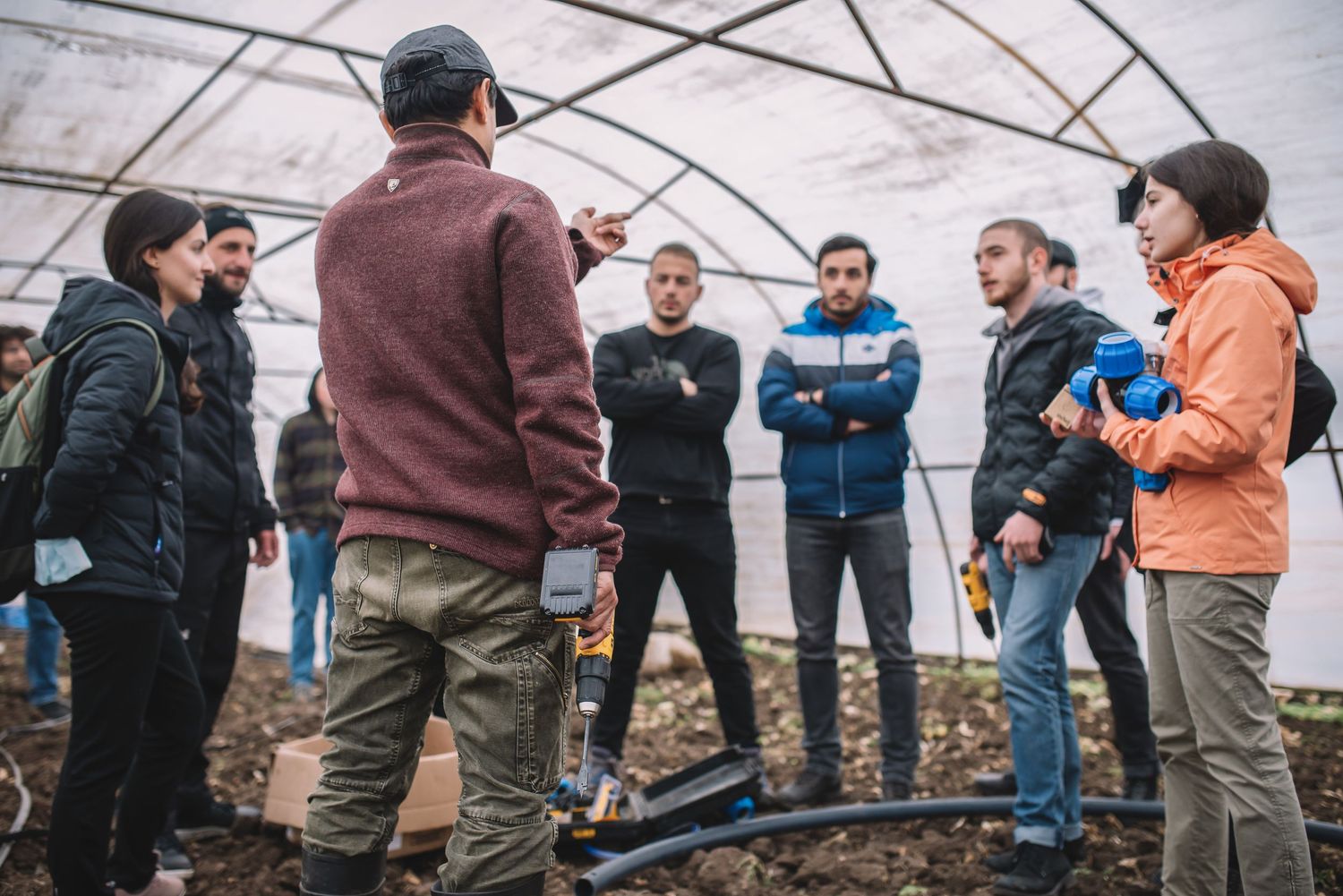Outdoor team-building or educational activity, featuring a speaker and attentive group in jackets—perfect for community, NGO, or nature educ