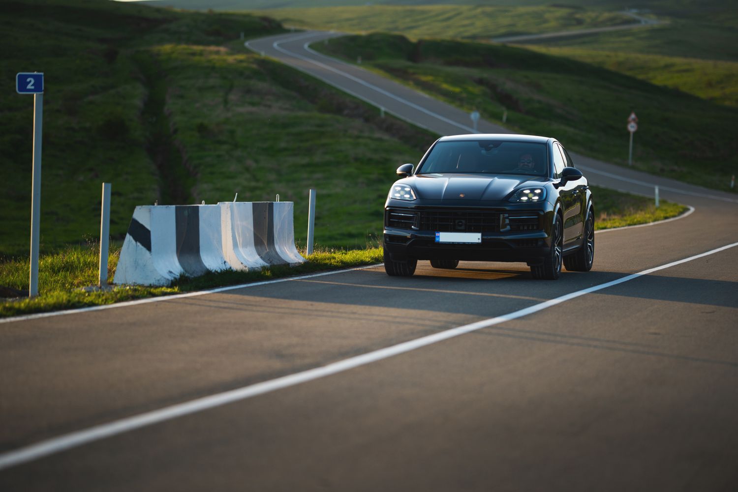 Black SUV in motion on a curvy highway — dynamic car photography on an open road.