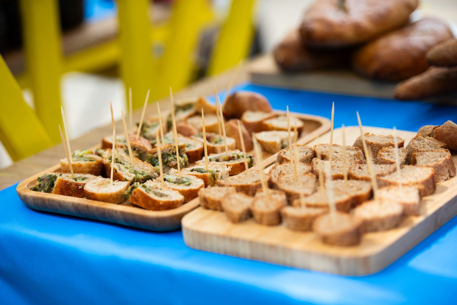 Variety of local pastries and cookies are displayed on a blue tablecloth.