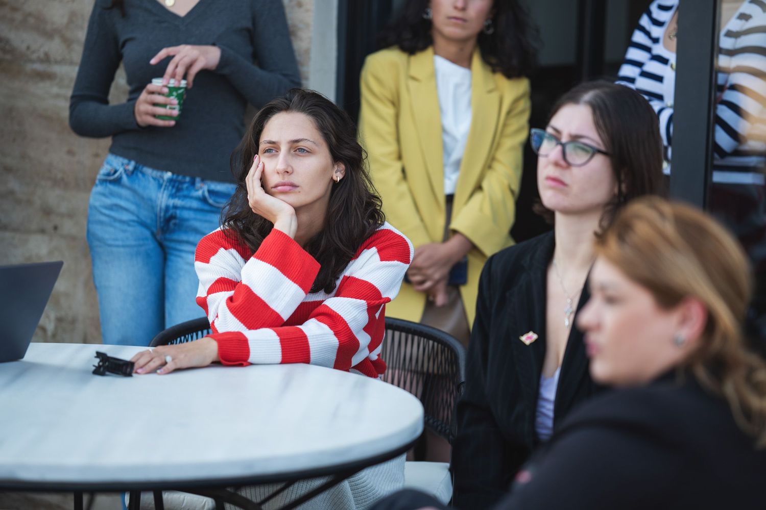 Young women attentively listening during an indoor seminar or discussion.