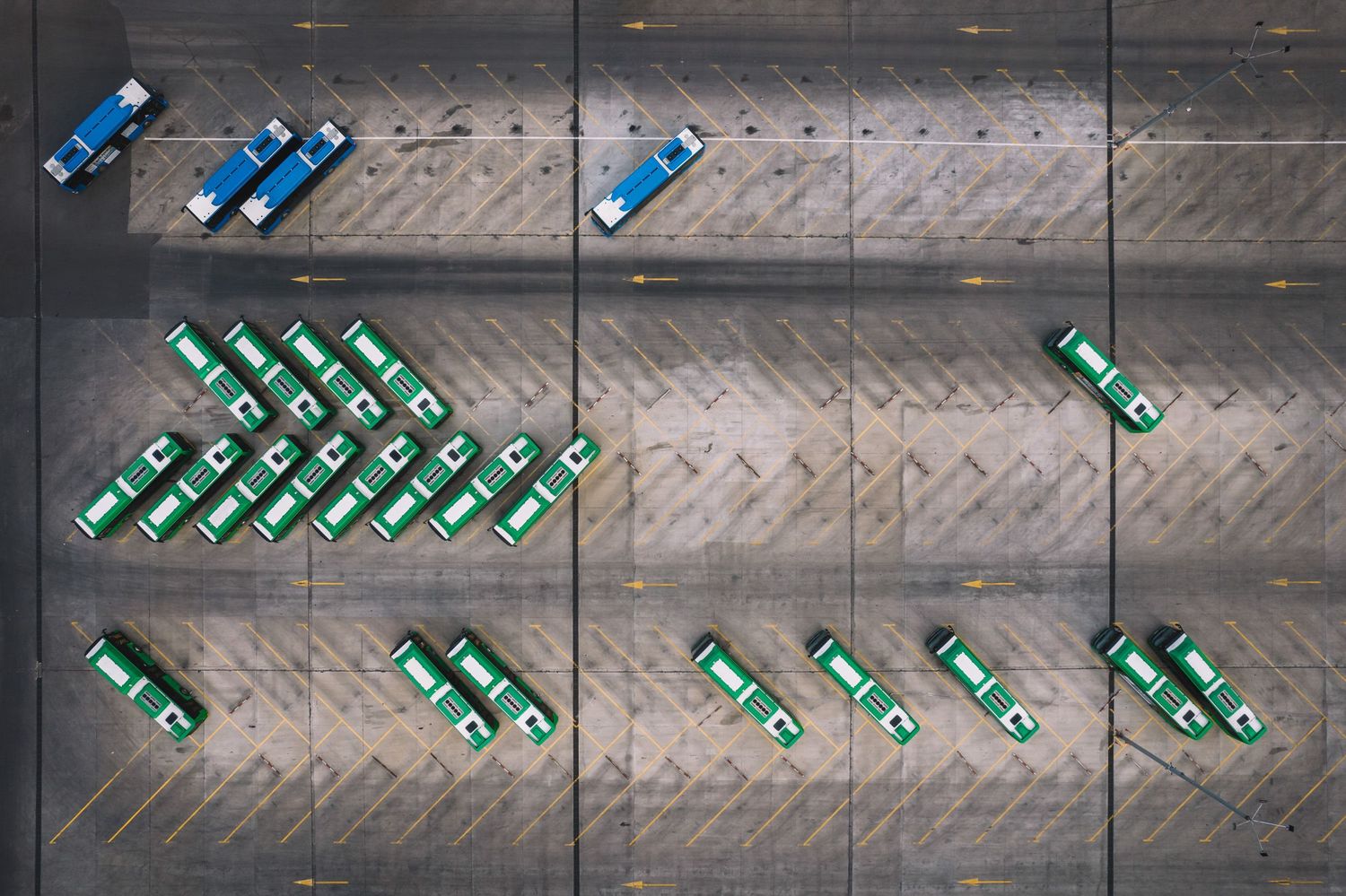 Minimalist drone shot of neatly arranged green bottles on an industrial surface.