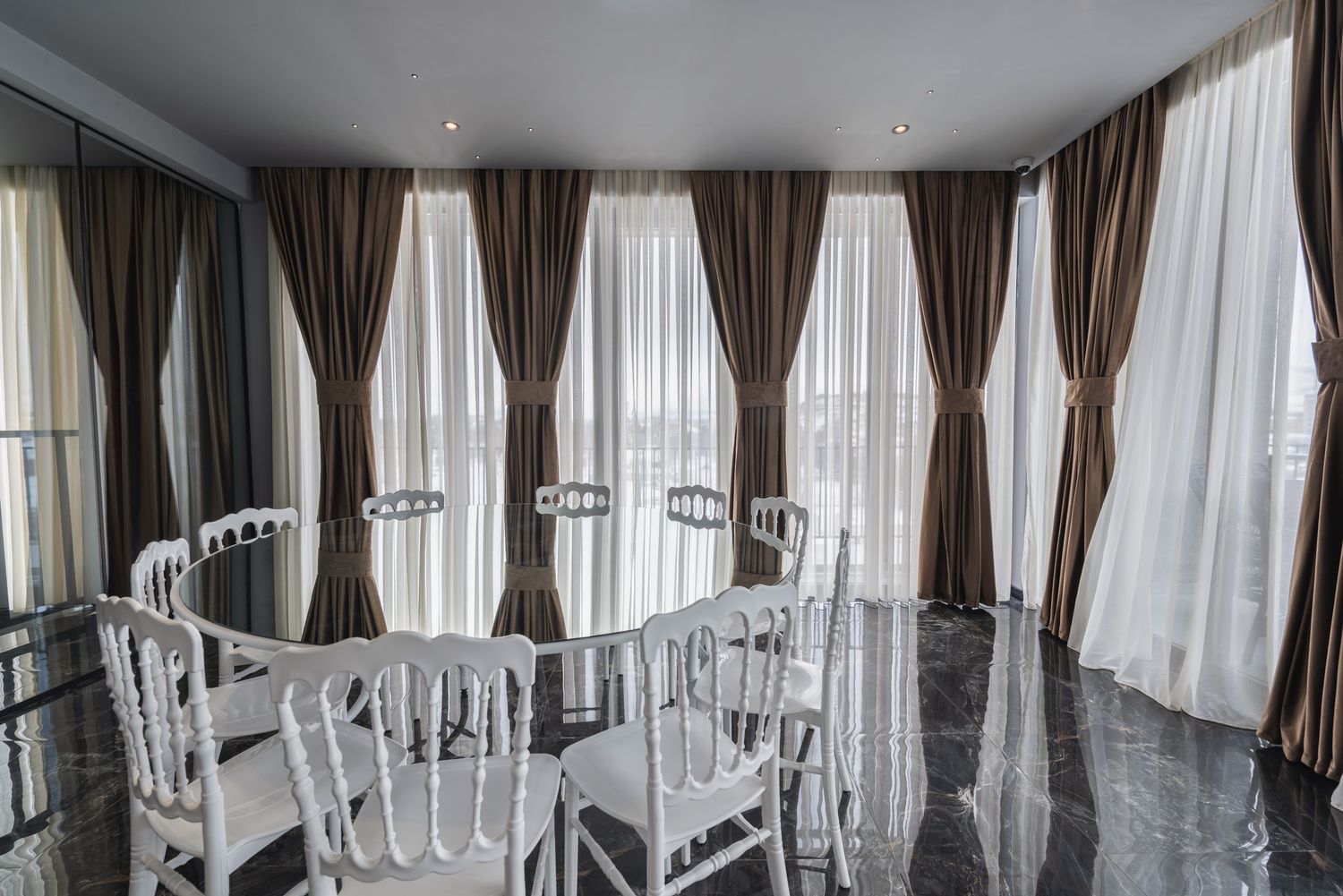 Elegant lounge or dining area with round tables and sheer curtains, suited for events or upscale dining.