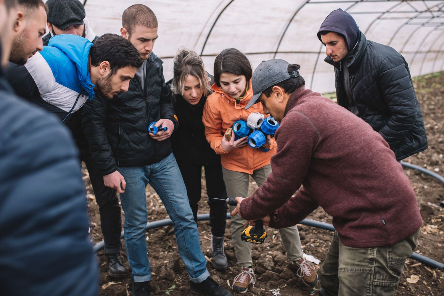 Students gathered around during an educational outdoor farming activity.