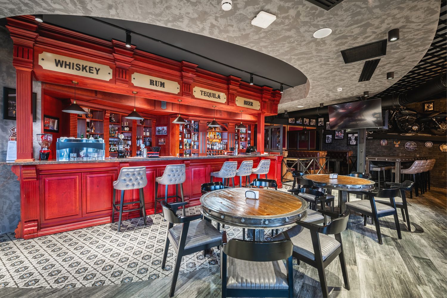 Classic tavern-style bar with a red counter, round tables, and a slightly vintage vibe, suitable for casual dining or drinks.