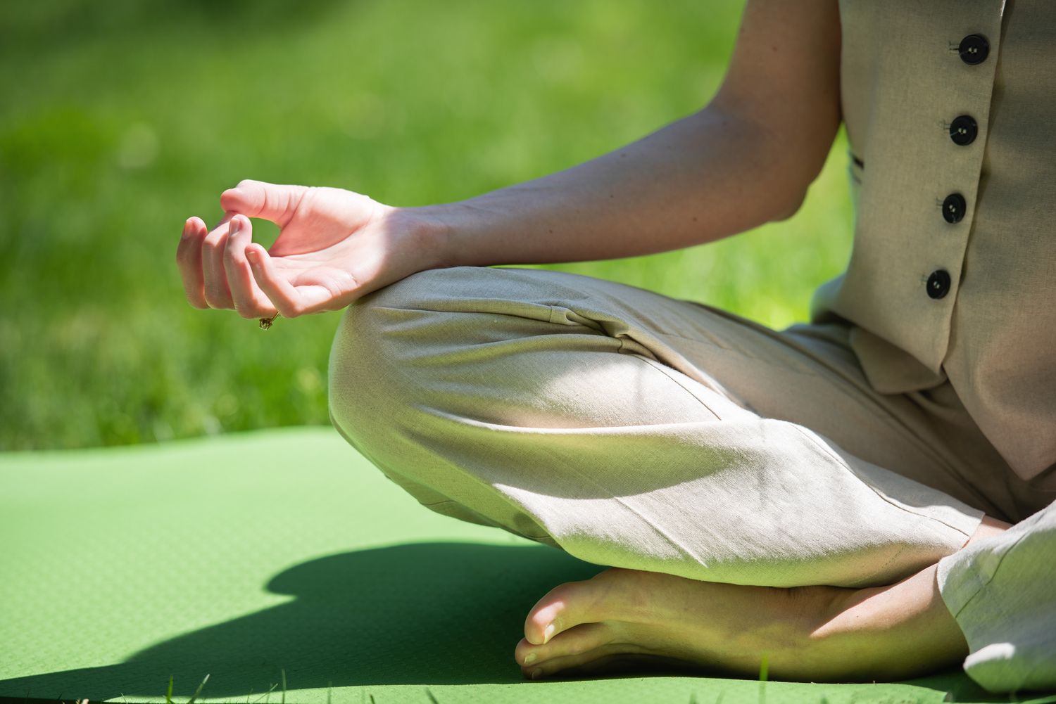 Close-up of a person sitting in lotus pose with hand in Gyan mudra — peaceful meditation moment.