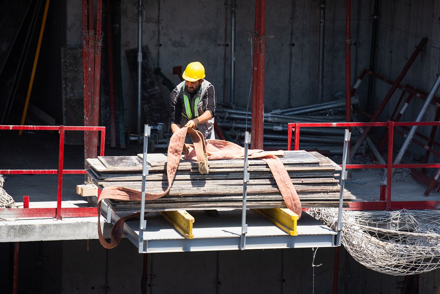 Construction workers pouring concrete into a foundation form at an early stage of development.