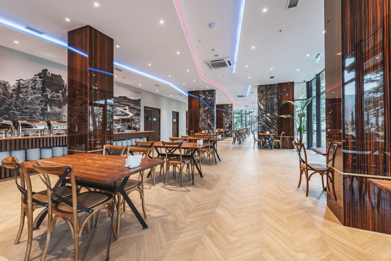 Modern commercial interior, featuring large glass partitions, wooden flooring, and industrial design elements.