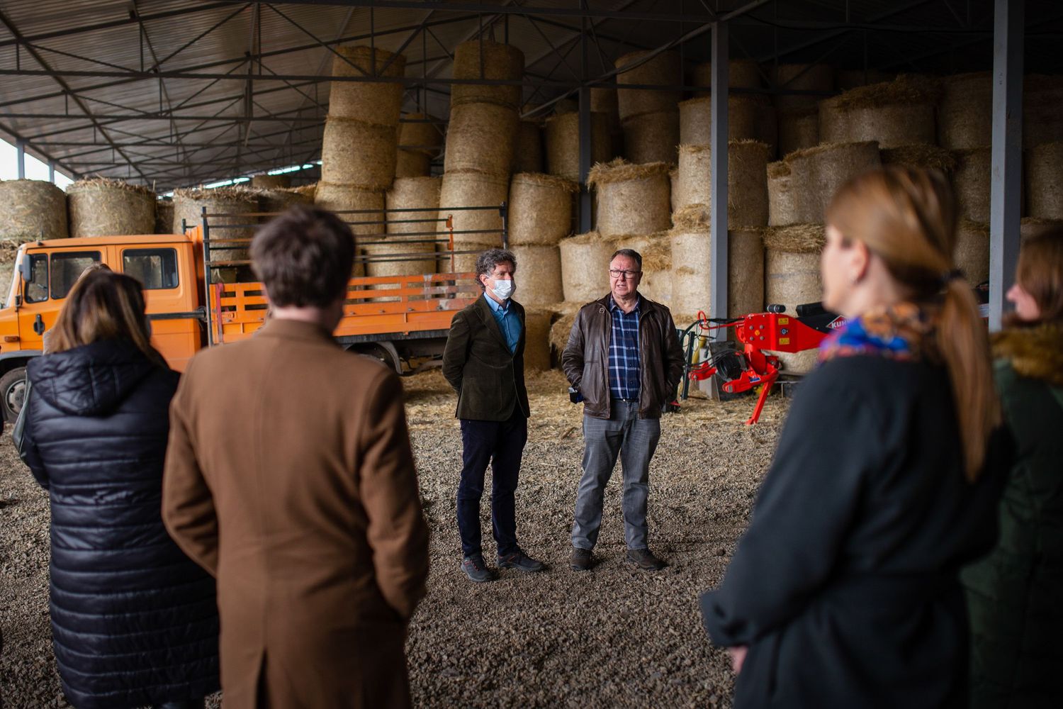 Group of people attending a guided tour inside a wine cellar.