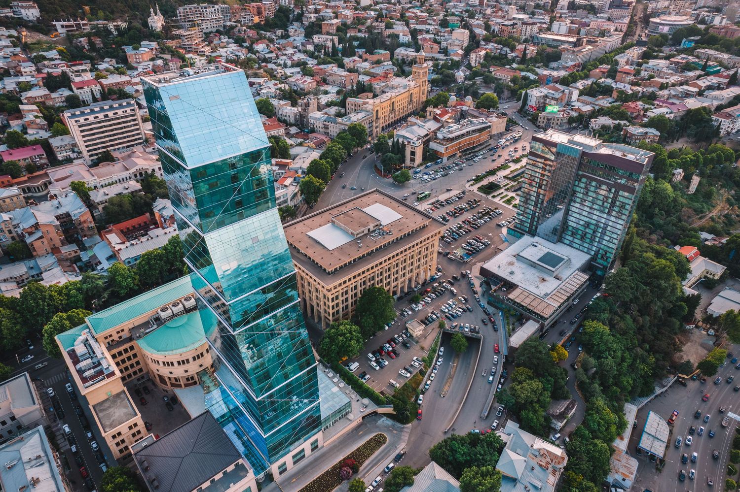 Aerial view of a city center with modern high-rise buildings and geometric rooftops.