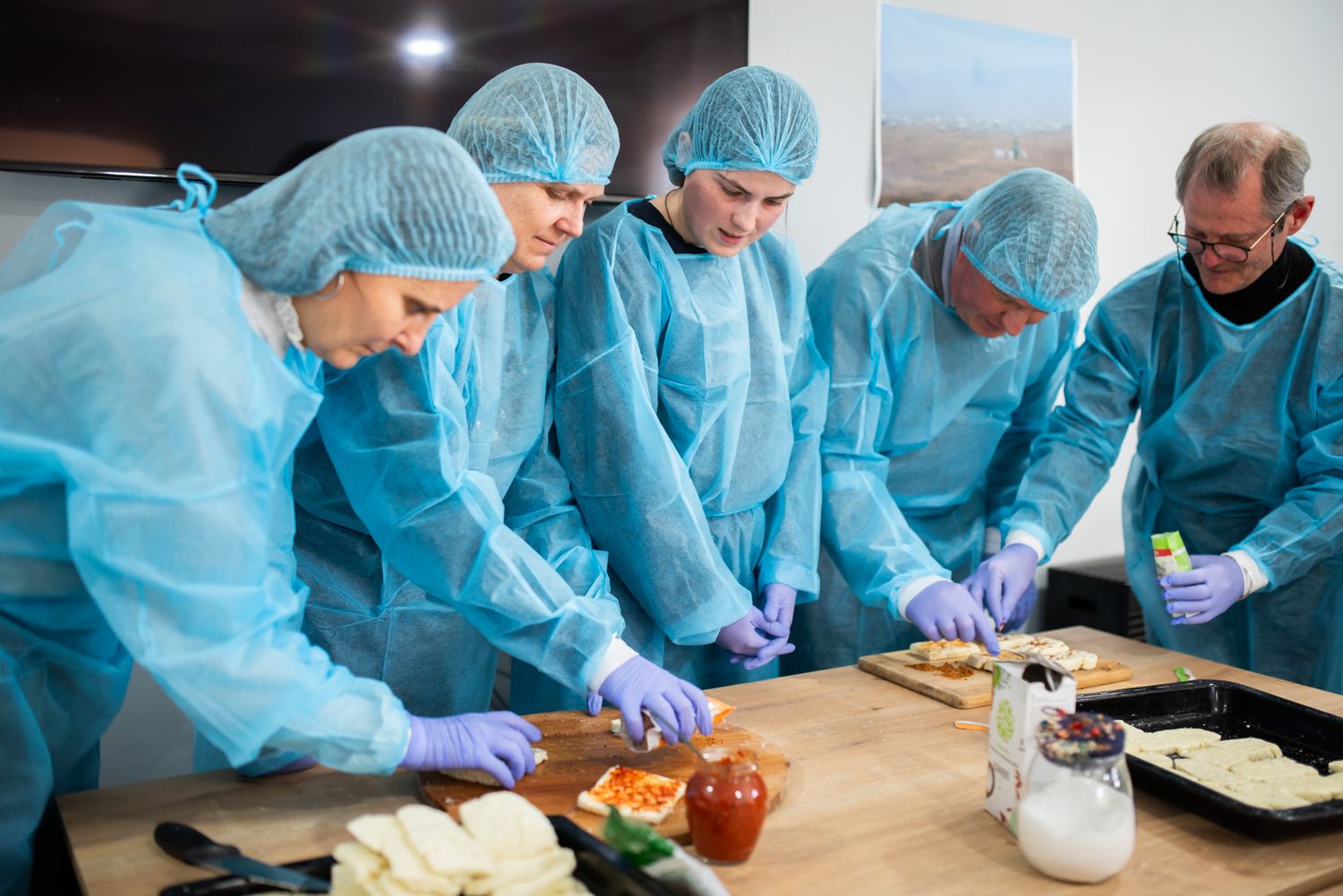 Team of scientists in protective gear analyzing food samples in laboratory.