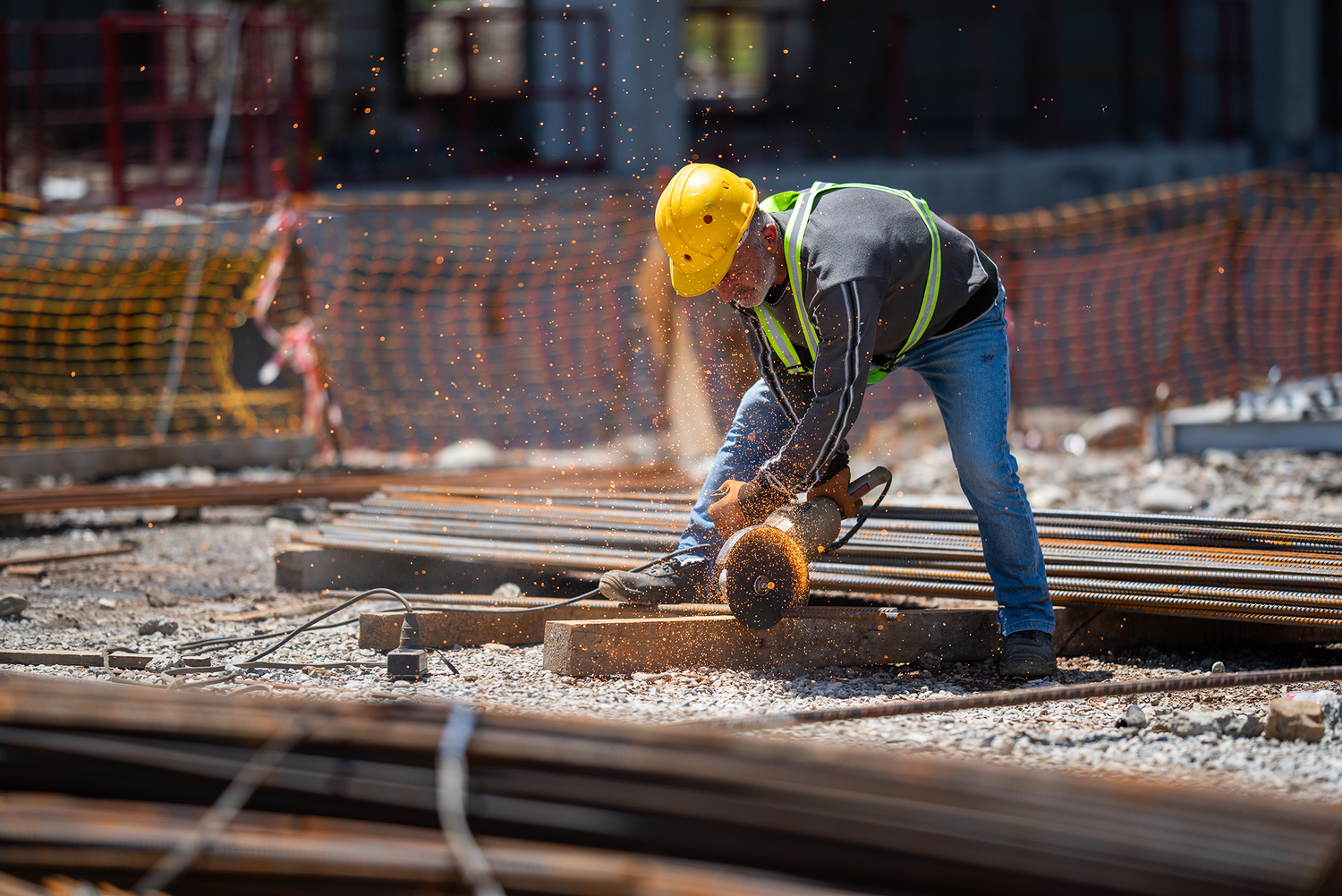 Construction worker measuring and working on a foundation with steel bars—emphasizes industrial labor, engineering, or infrastructure themes