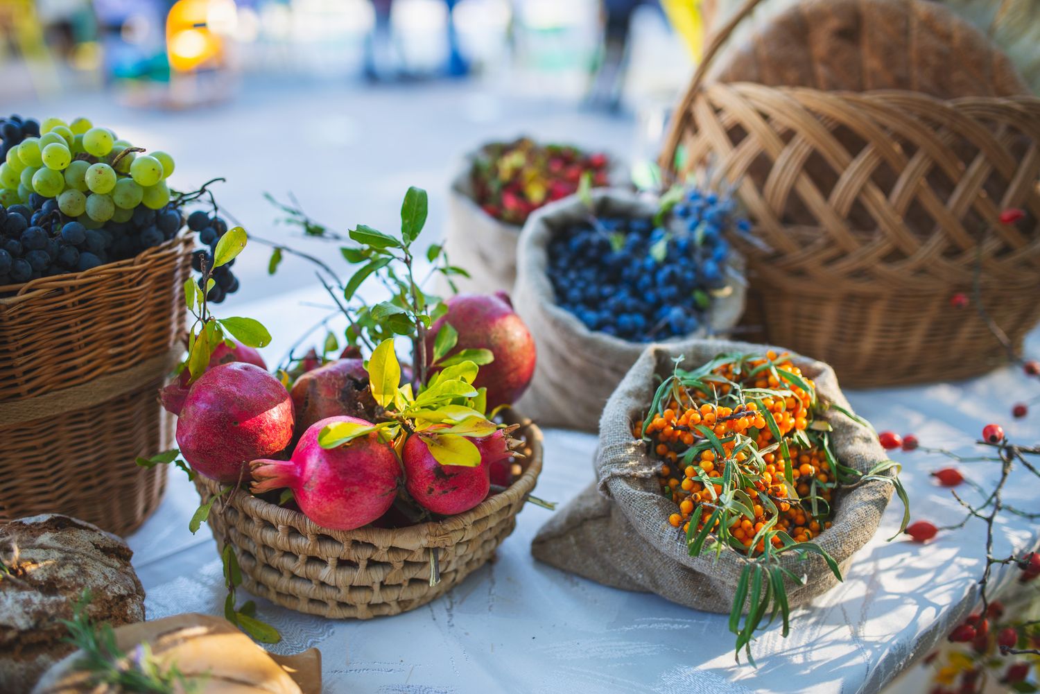 Colorful fresh fruits and vegetables displayed in traditional baskets on an outdoor table.
