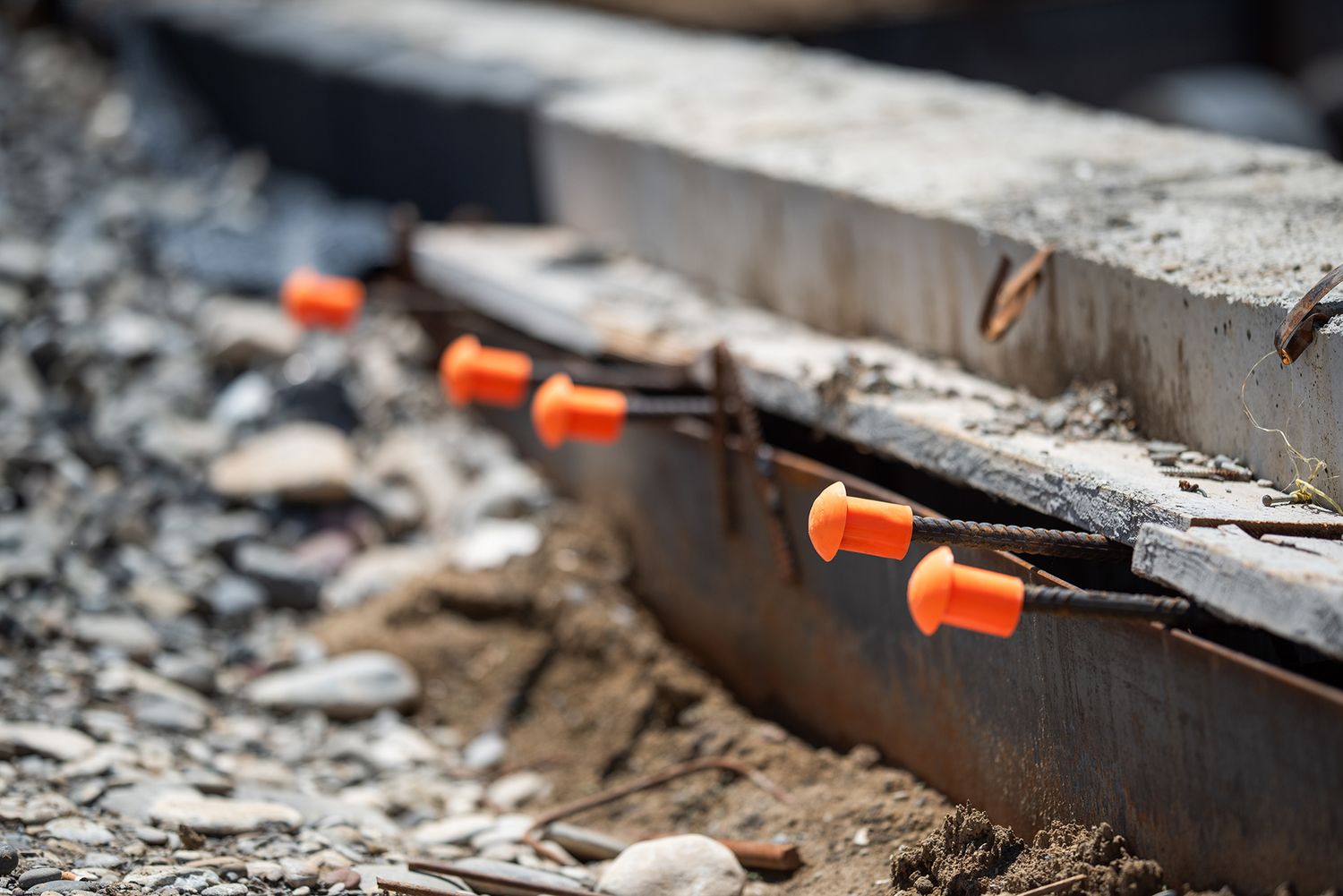 Close-up of embedded electrical conduits and piping in concrete, construction in progress.
