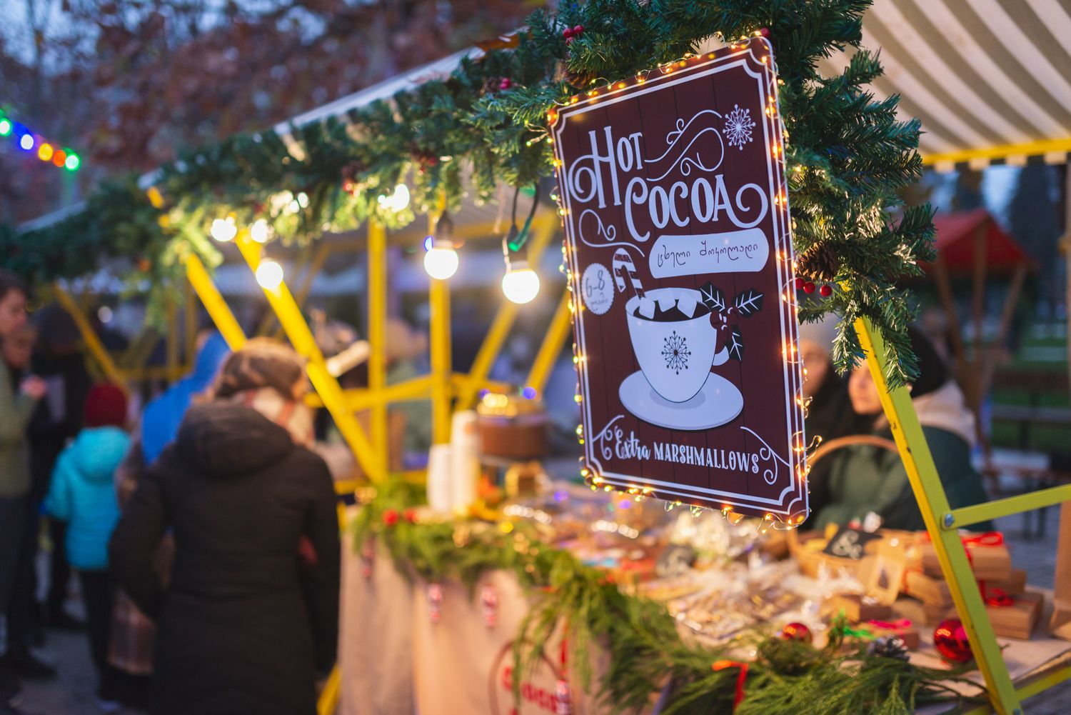 Candles and decorative elements arranged at a vibrant outdoor market during nighttime.
