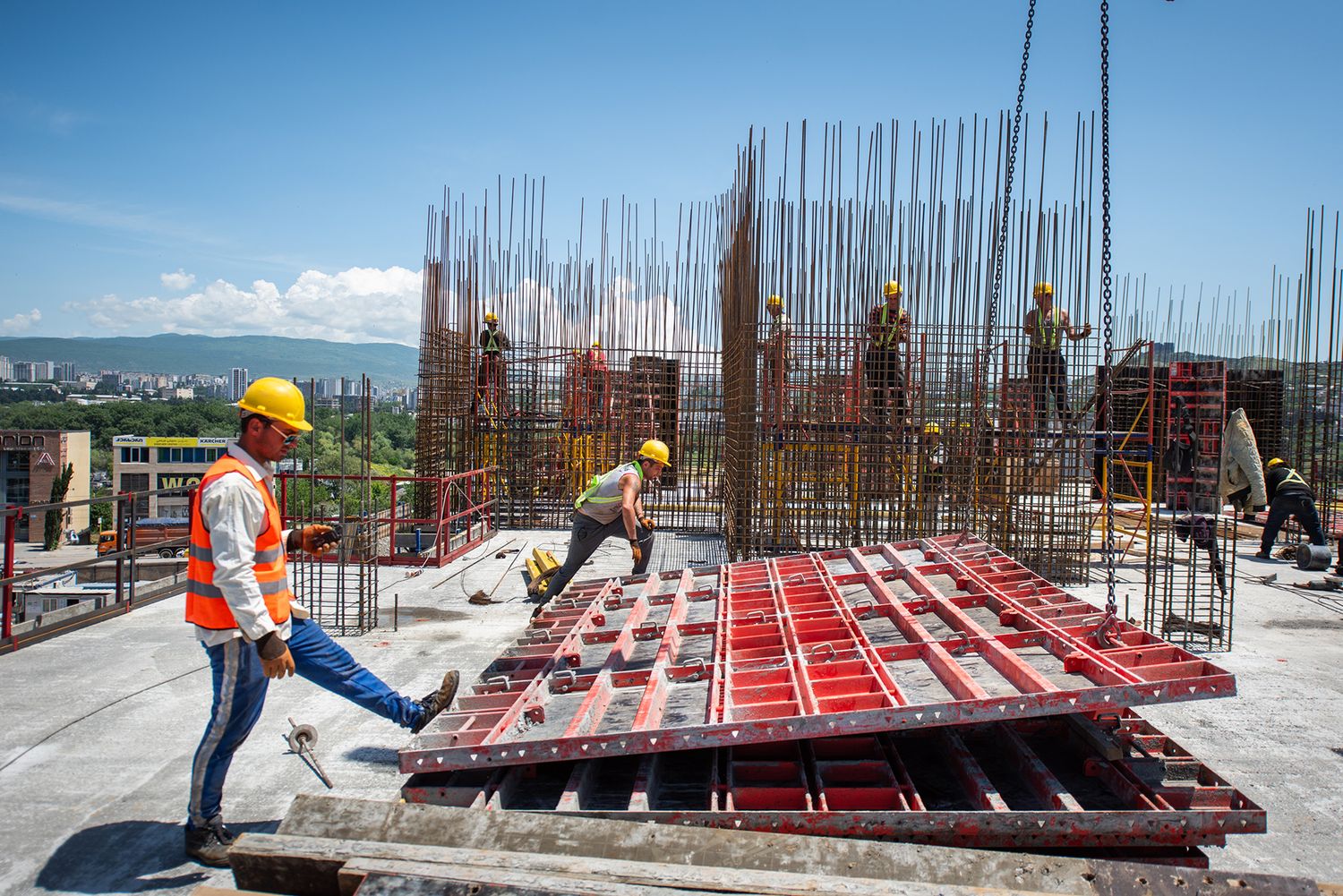 Engineer or worker inspecting construction progress at a reinforced concrete site.