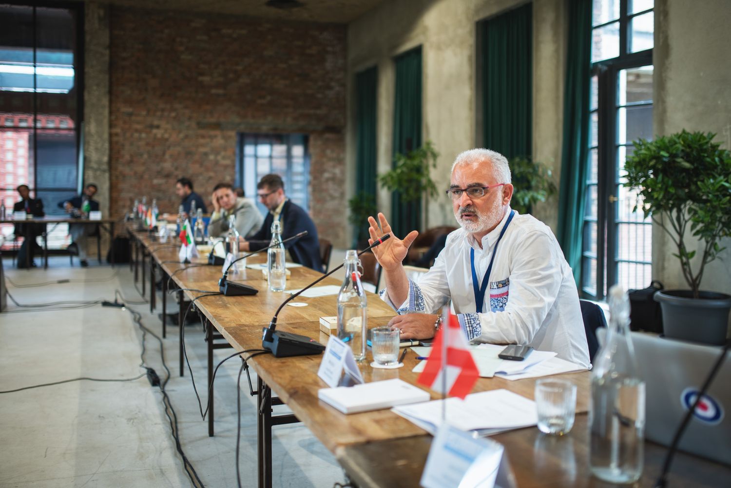 Professional networking event or breakfast meeting in a modern cafe-style setting, participants in white attire.