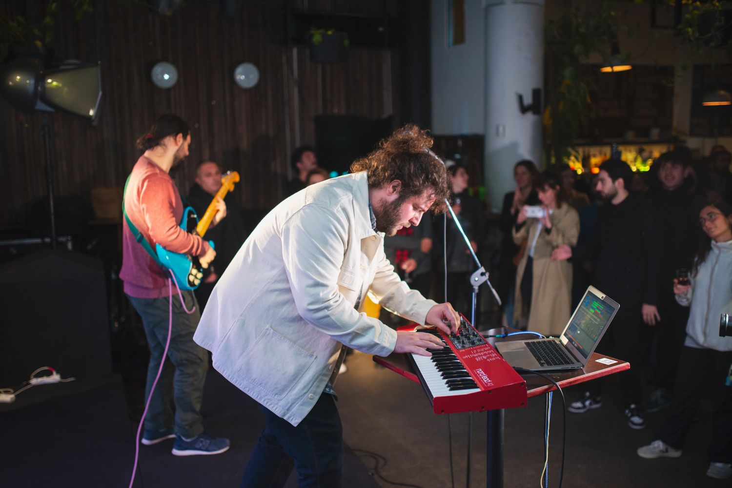 A DJ performing live at an indoor event, engaging the audience with energetic music.