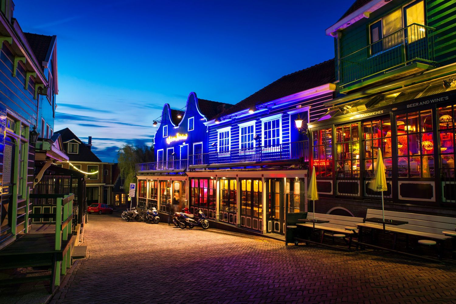 Colorful storefronts and neon lights in a lively evening street scene — vibrant nightlife atmosphere.