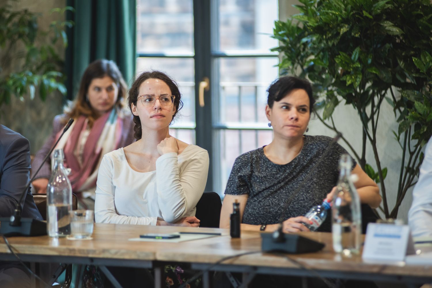 Three women in a casual cafe setting, possibly during a small business meeting or brainstorming session.