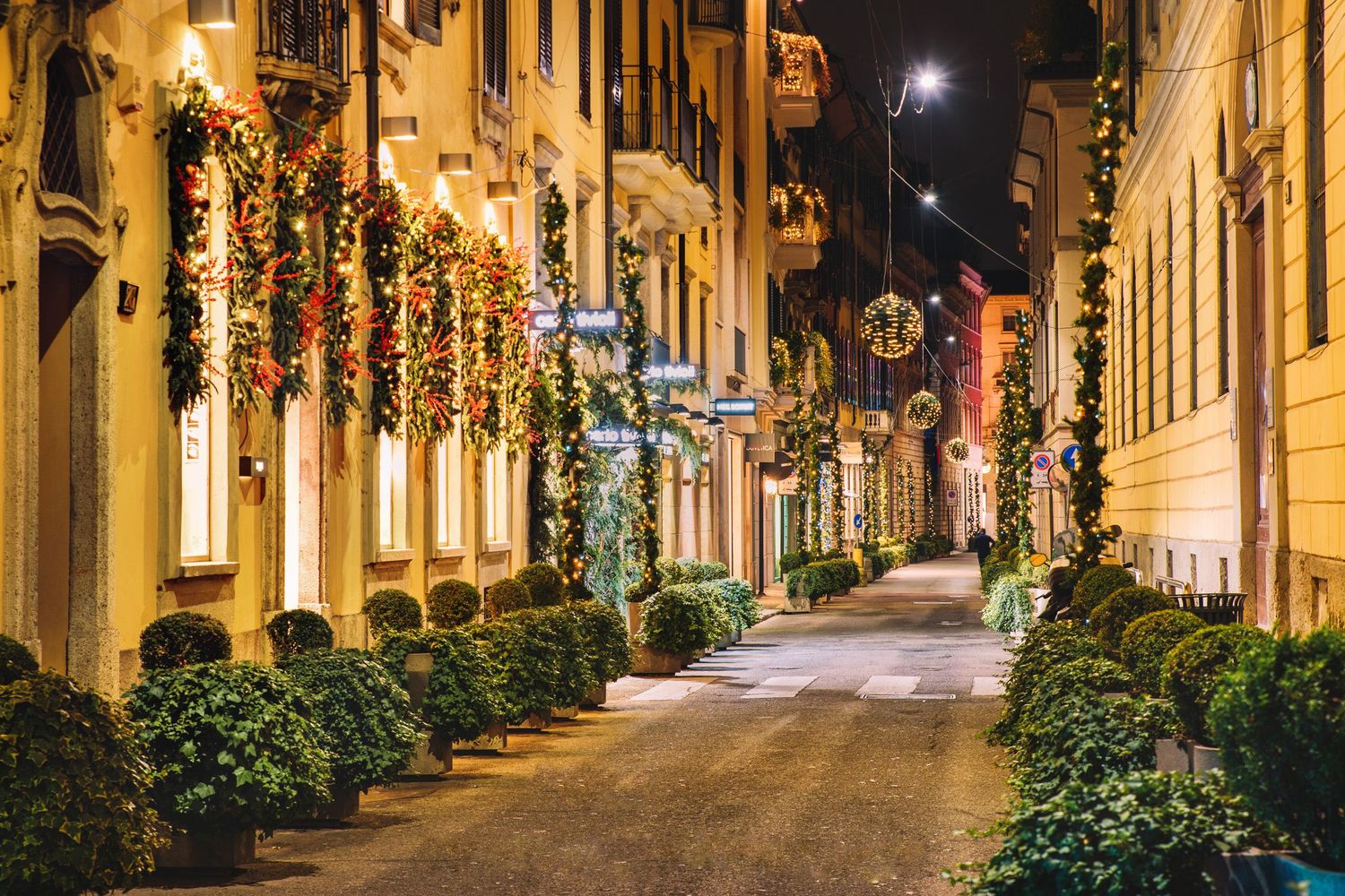Charming narrow street illuminated by warm lanterns — cozy European evening alley.