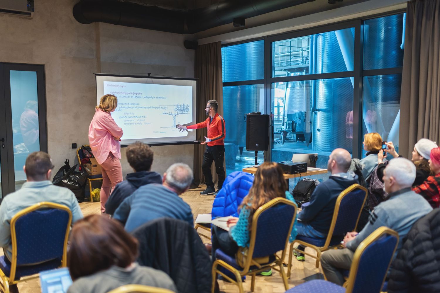 Indoor seminar or business meeting with a speaker addressing an audience—suited for corporate, training, or academic use.