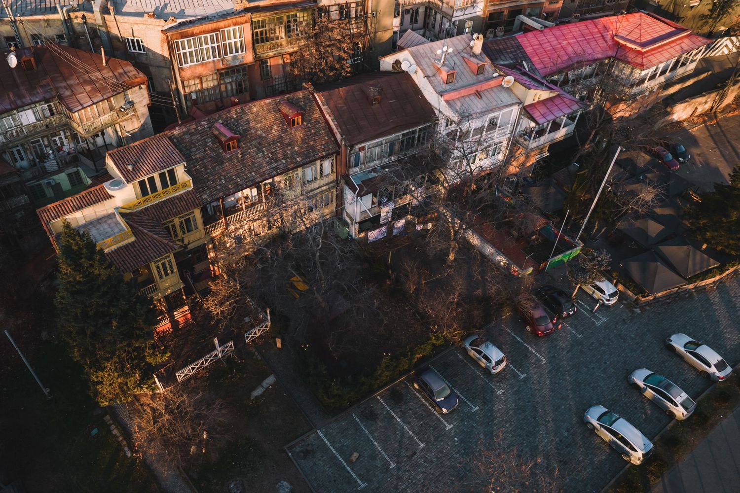 Evening aerial capture of an urban neighborhood with apartment complexes and parked cars.