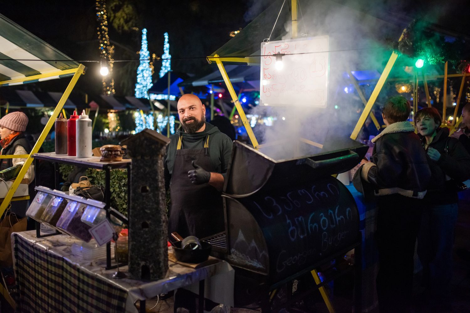Nighttime street performance with dramatic lighting during an outdoor cultural event.