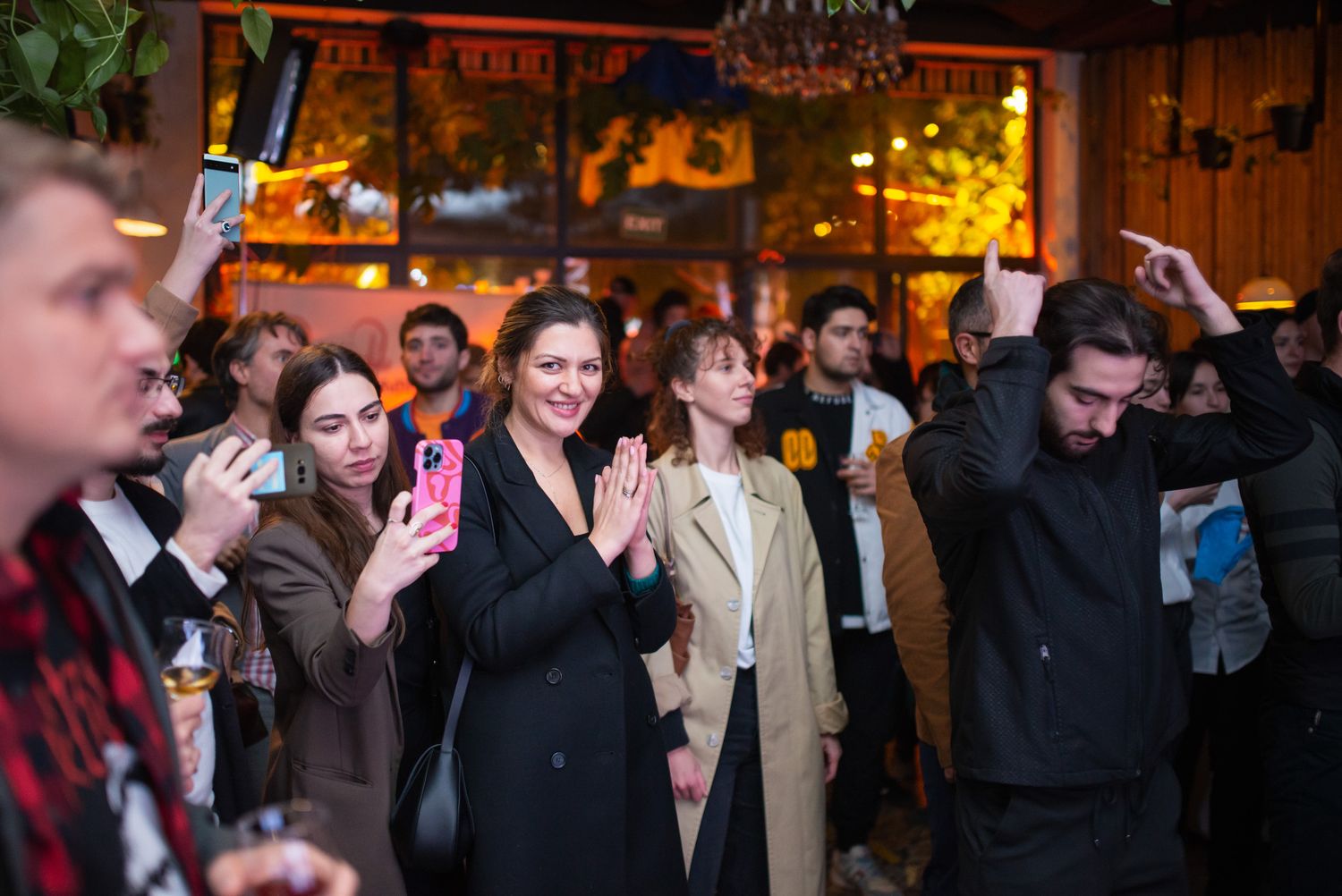 Happy group of people celebrating or performing at a nighttime venue, possibly a live show or party.