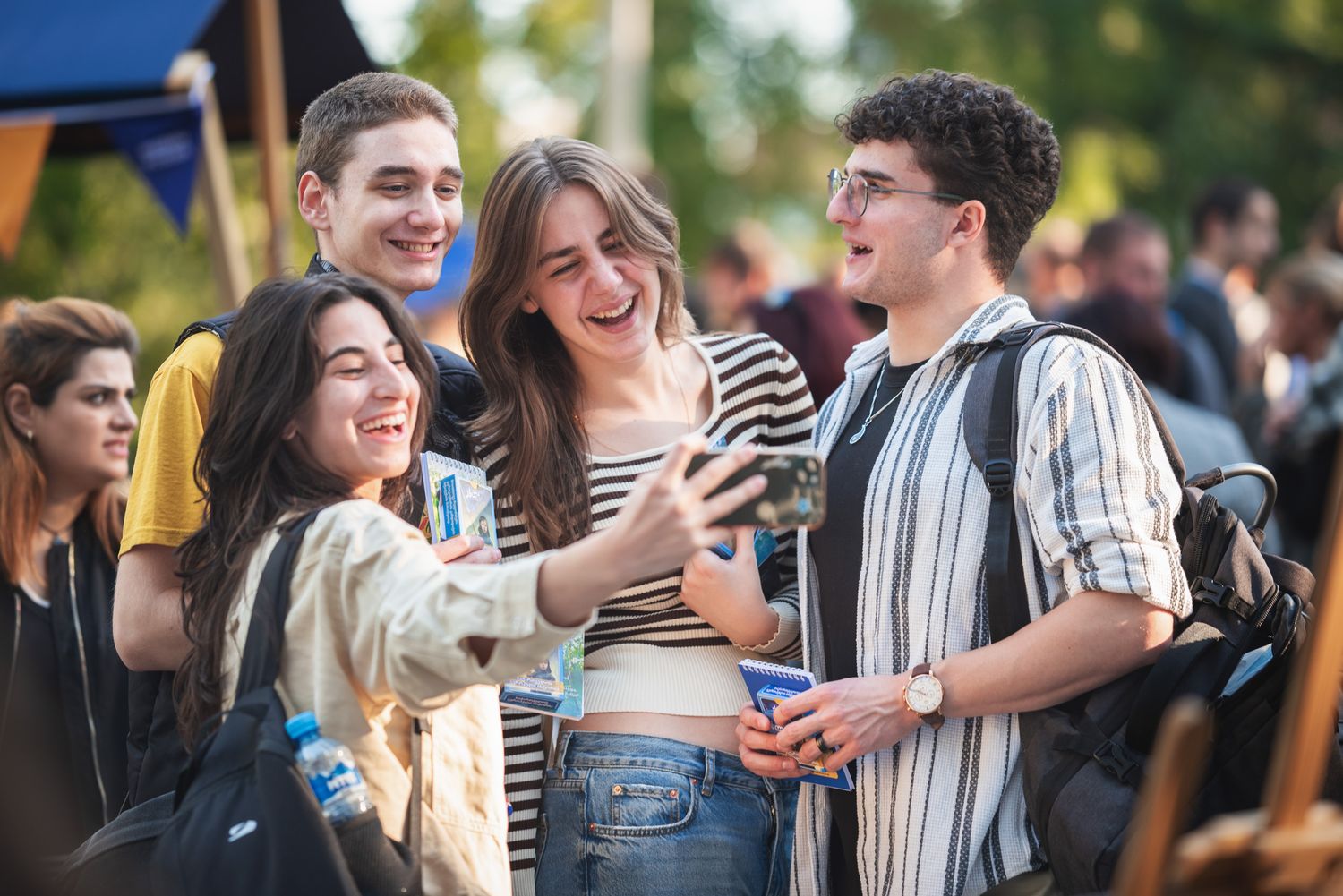 Group of young people chatting and enjoying a casual outdoor event in traditional attire.