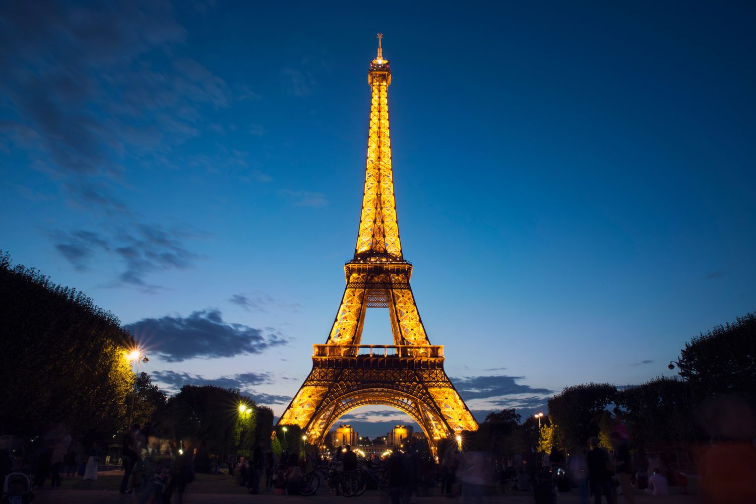 Eiffel Tower illuminated at twilight with a deep blue sky — iconic Paris landmark at dusk.