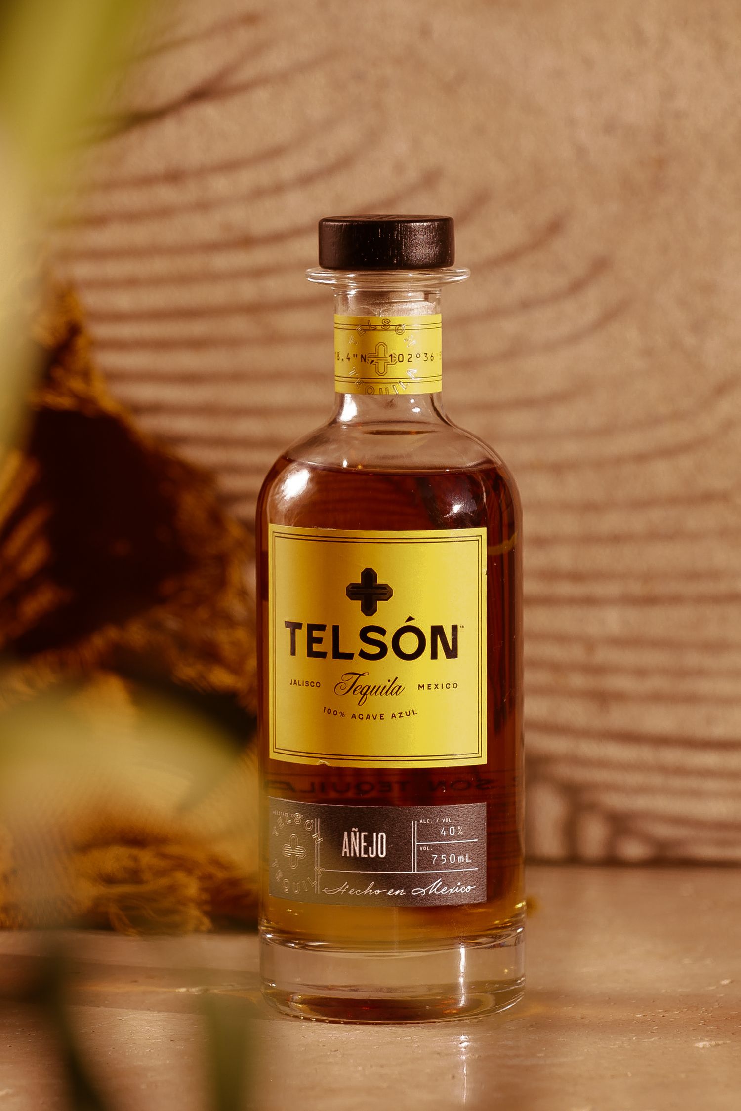 Bottle of Telson spirits photographed against textured background with warm lighting.