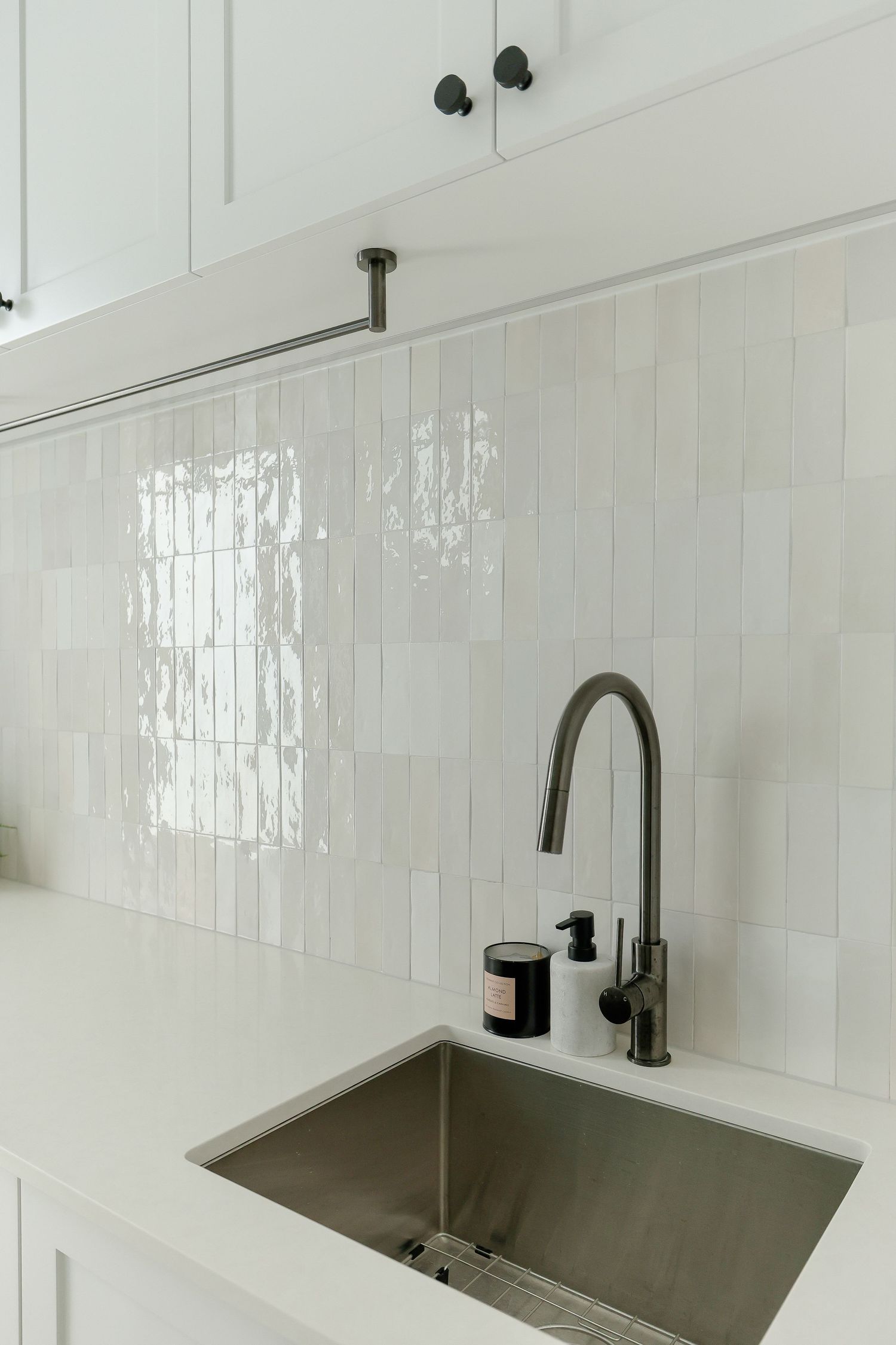 Clean white kitchen with modern cabinets and sleek stainless steel undermount sink.
