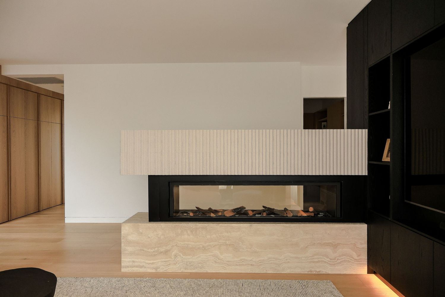 Modern interior design features a sleek fireplace with horizontal flames and minimalist black and white decor.