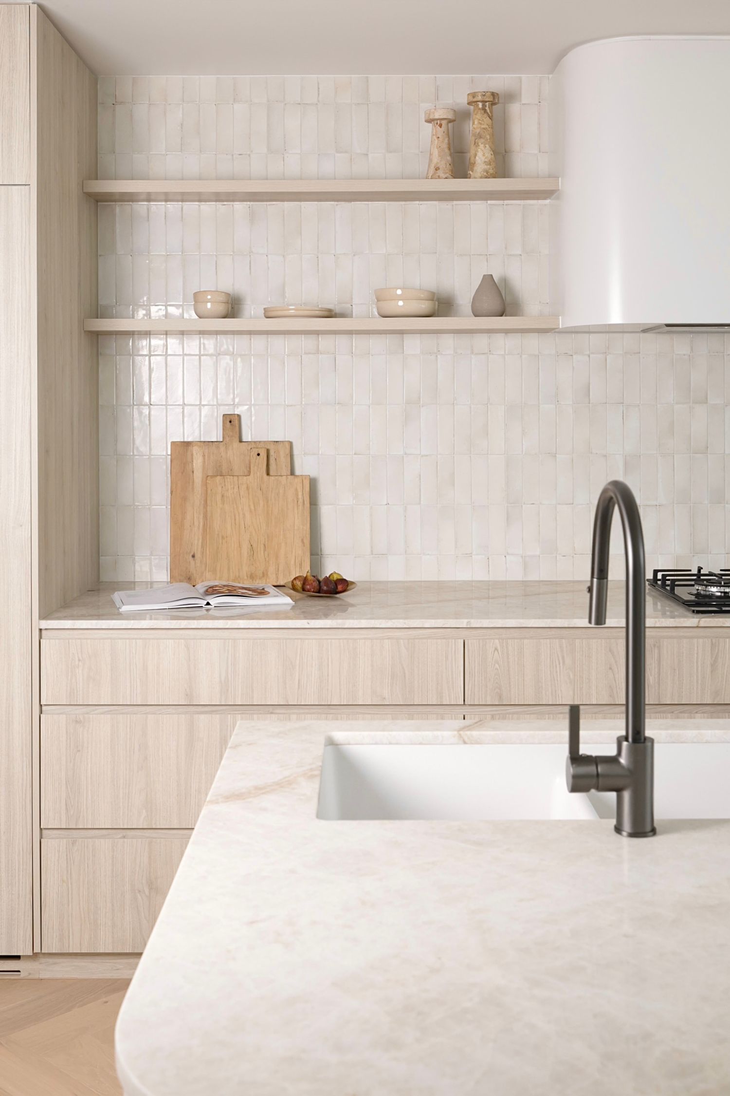 Clean white kitchen design with vertical tile backsplash and matte black fixtures.