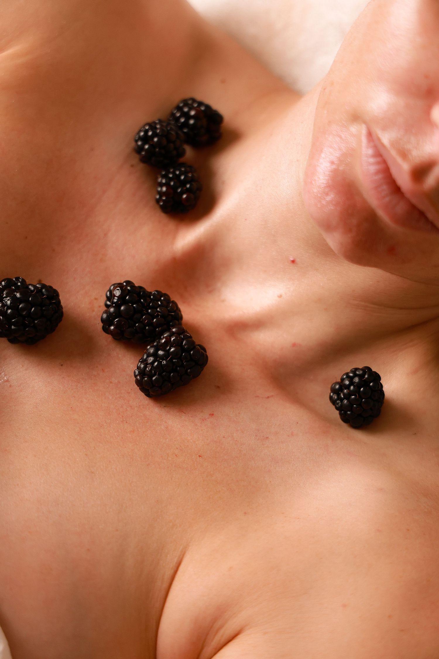 Artistic composition of fresh blackberries arranged on skin in natural lighting.