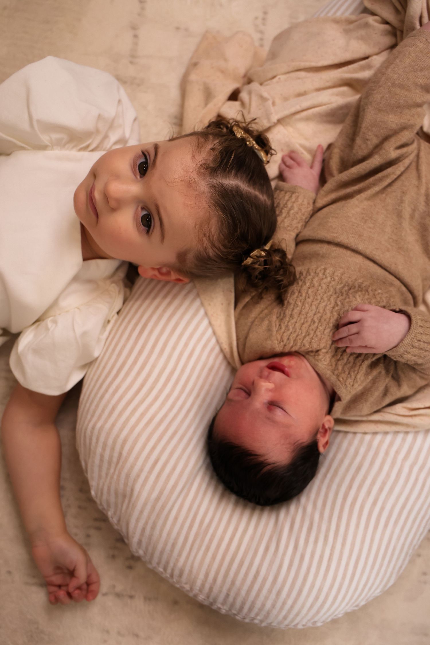 Couple lying together on striped pillow in cozy embrace.