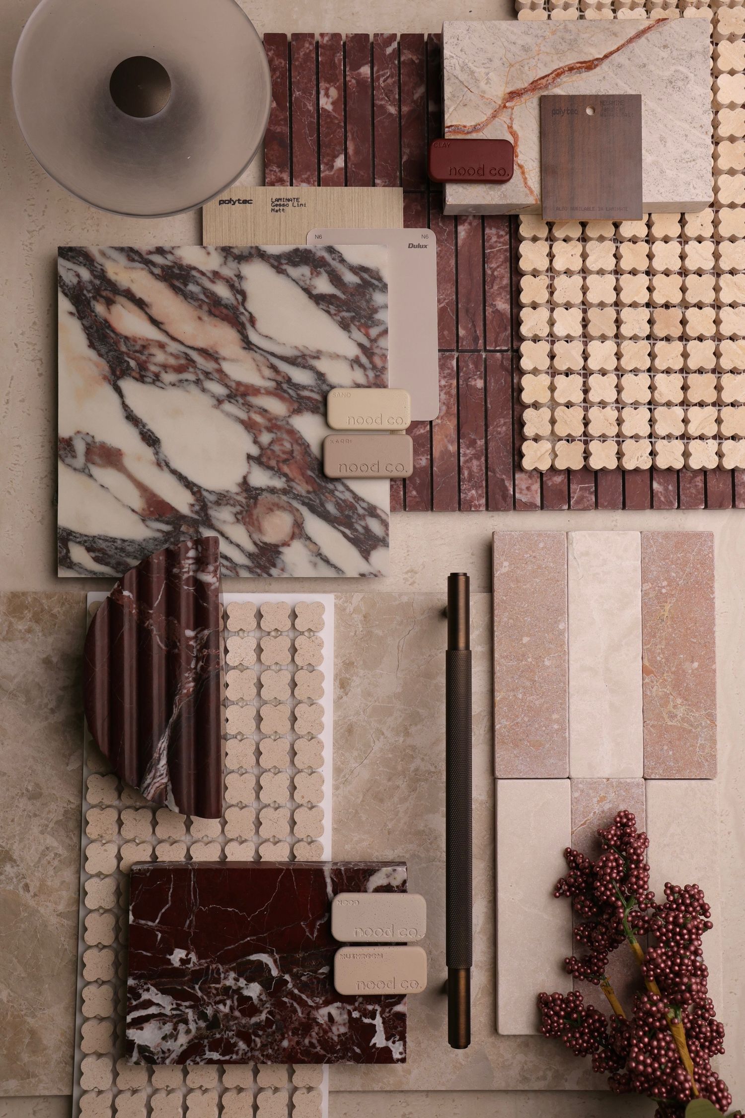Overhead view of material samples including marble, wood, and fabric swatches arranged in a modern interior design layout.