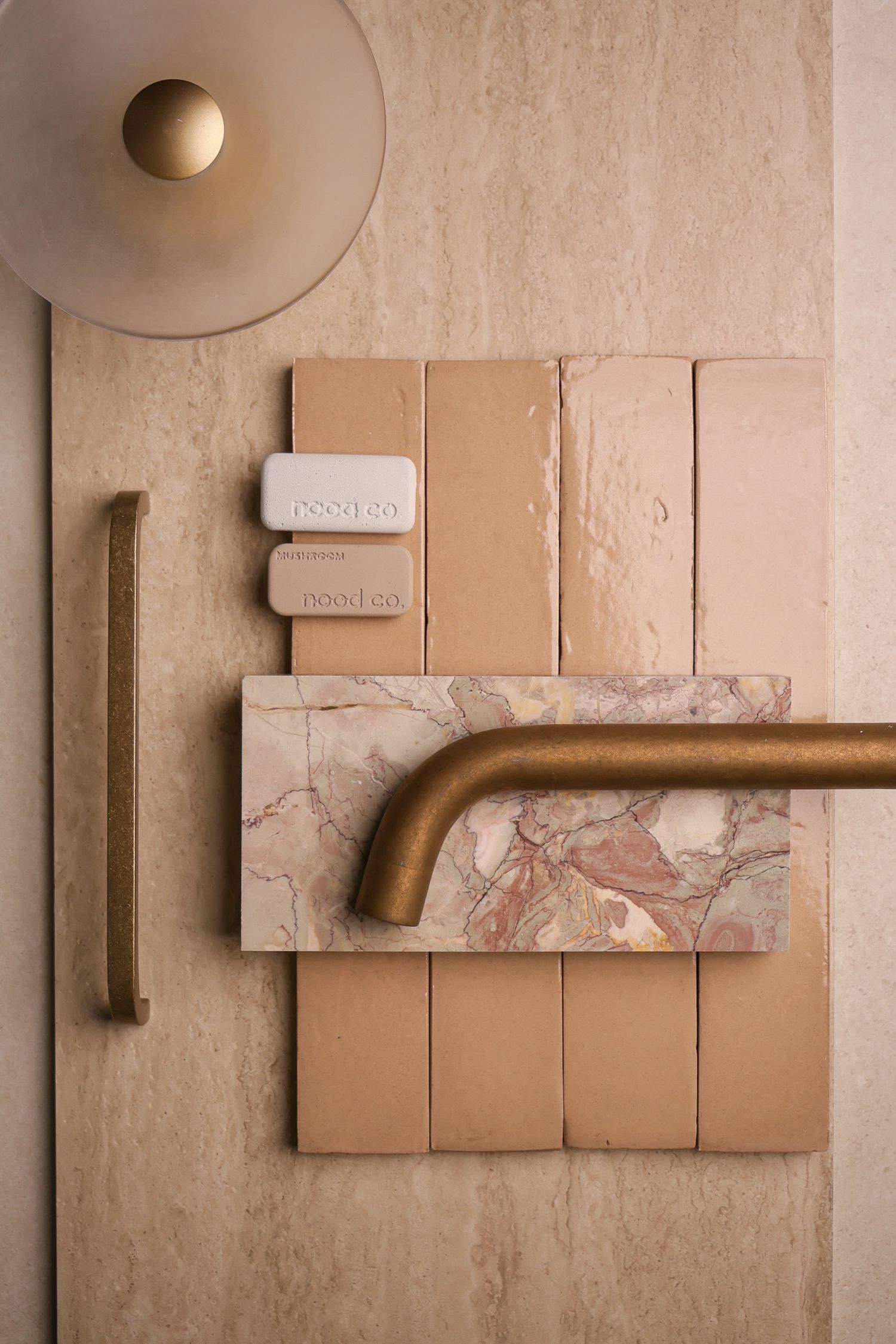 Modern interior design elements featuring neutral tones, brass hardware and marble textures.