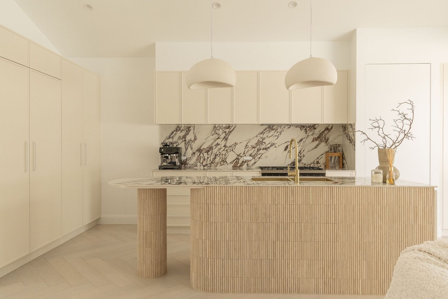 Minimalist open concept kitchen with light wood cabinetry and clean white walls.