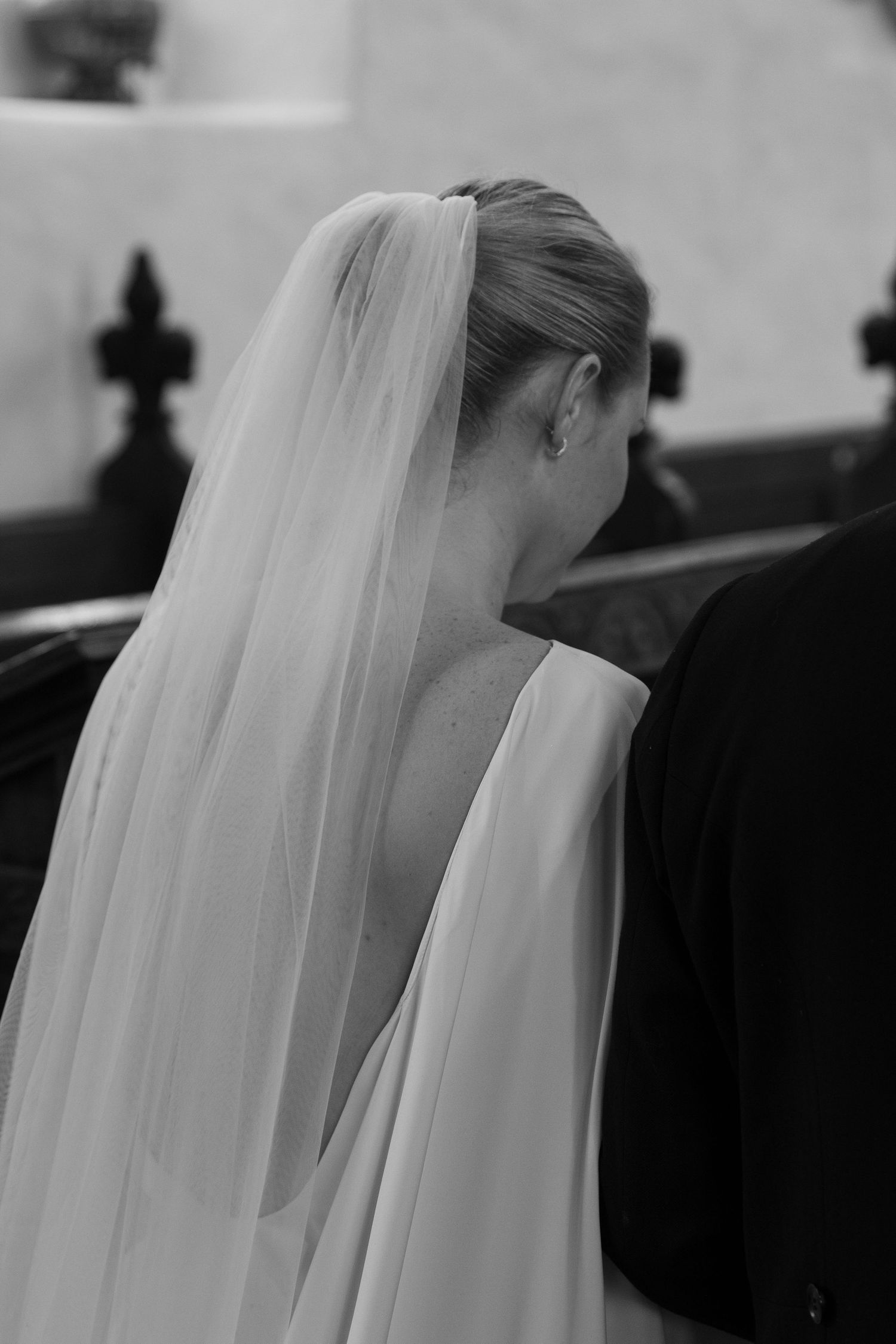 A close-up black and white shot of a bride's veil flowing in gentle movement.