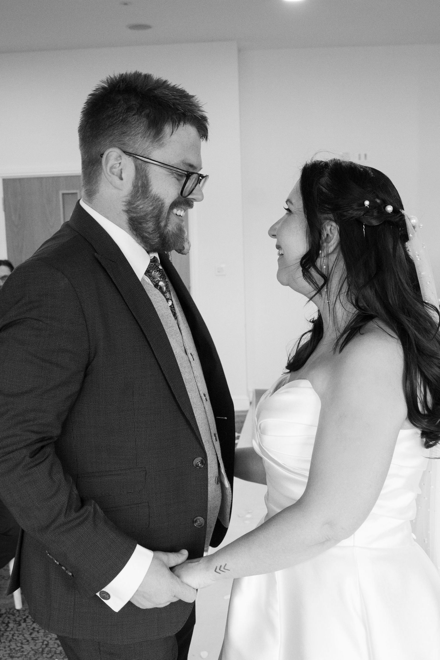 Black and white romantic wedding moment captured in an intimate indoor setting.