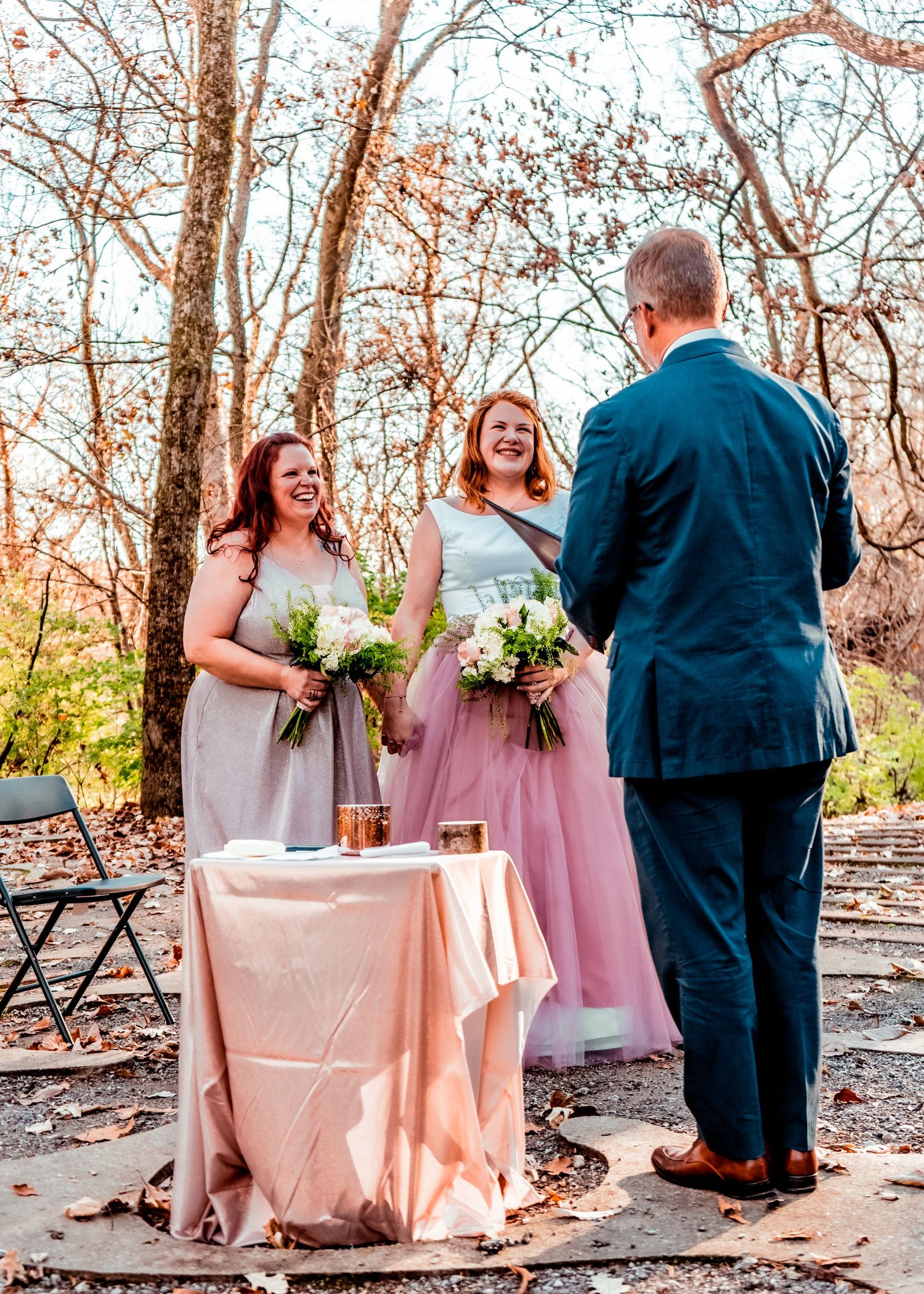 Another candidly beautiful moment of the brides with bouquets in hand in front of the pastor.