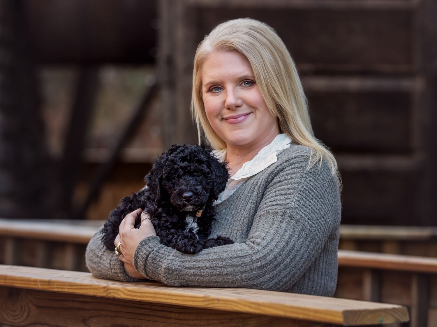 Woman holds black puppy at a park during pet photography session at Norris Lake in Tennessee