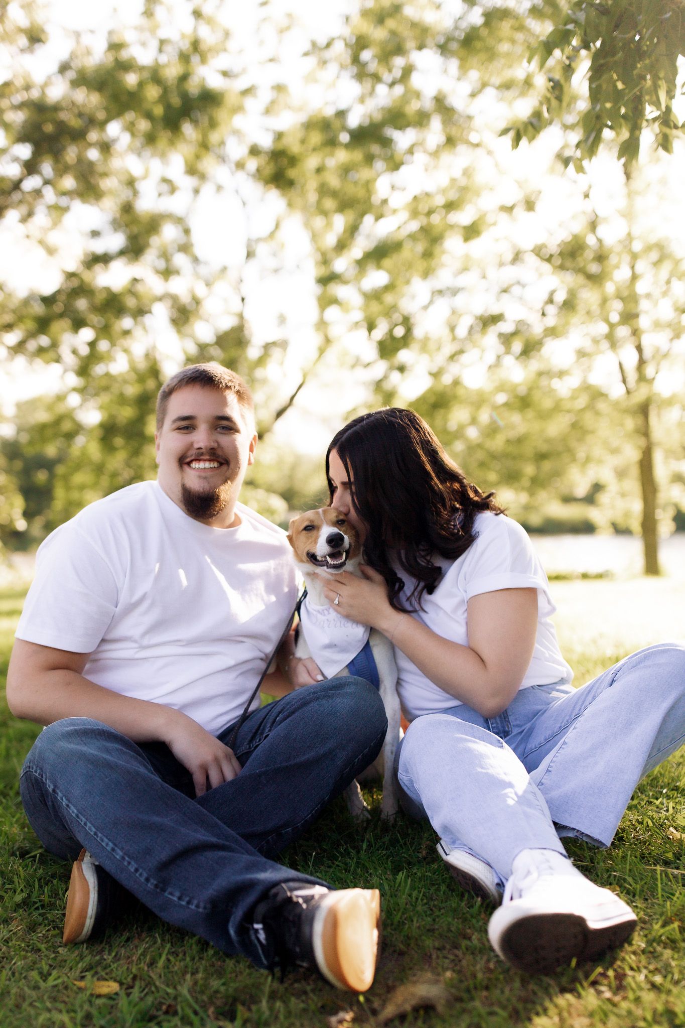 Couple laughing with their dog during an engagement photo session, captured by Jessica Rose Photography in Janesville, Wisconsin.